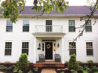 Traditional white two story home with balcony and white double-hung windows