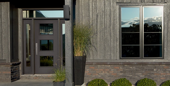 the exterior of a dark-colored home with a 3 light equal front door