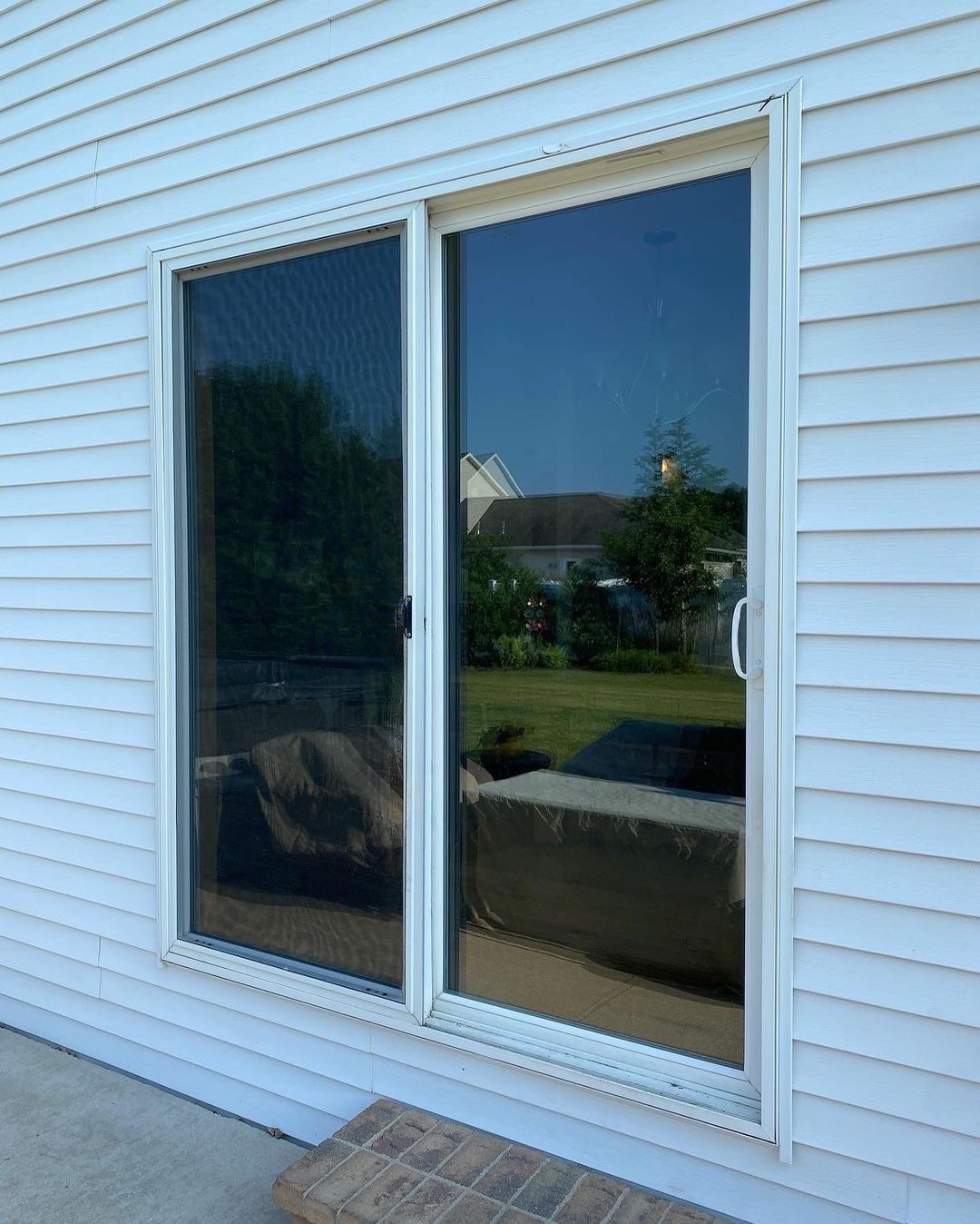 an old sliding glass door before being replaced with a new black sliding door
