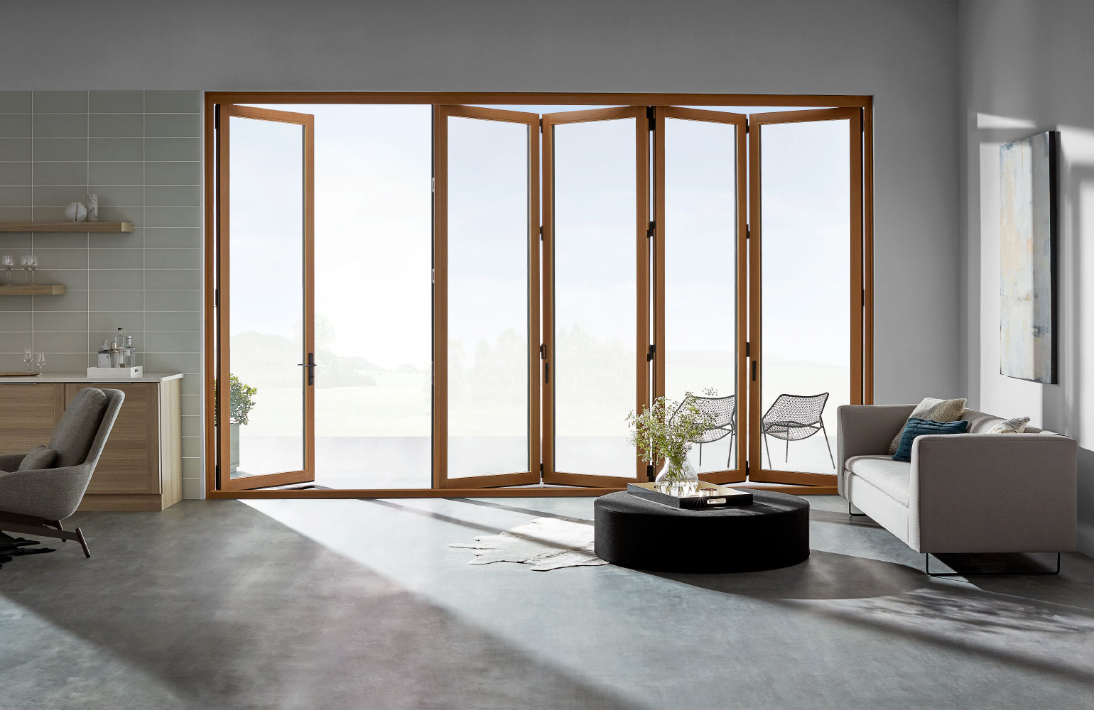living room with light wood stained bifold patio doors partly open