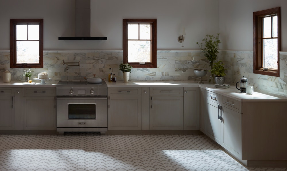 Wood stain windows contrast against neutral colored kitchen floor and cabinets