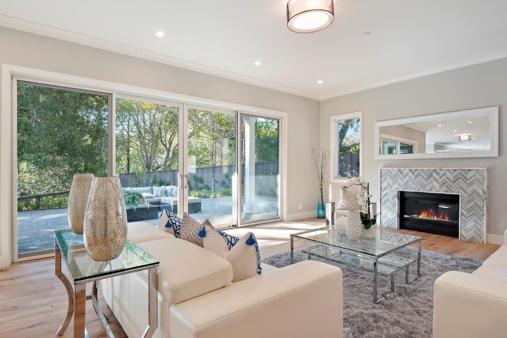 A wall of sliding glass doors brings light into neutral colored living room