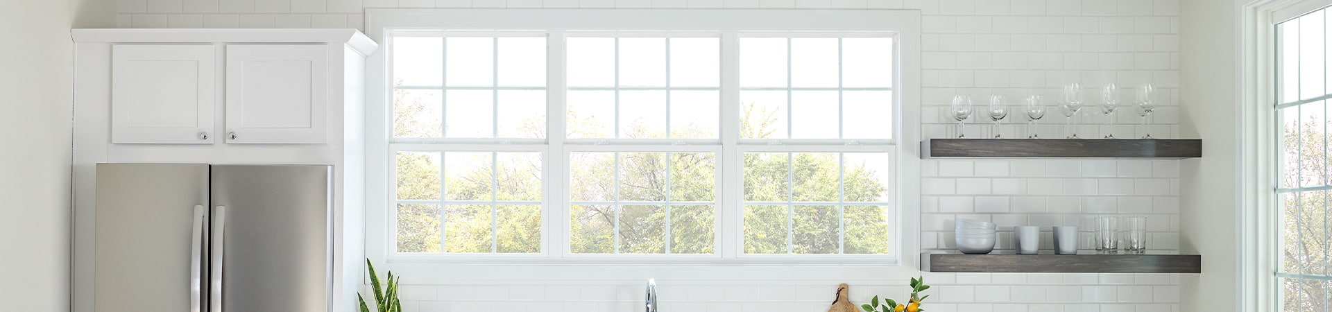 three single-hung windows in a white kitchen with orange barstools