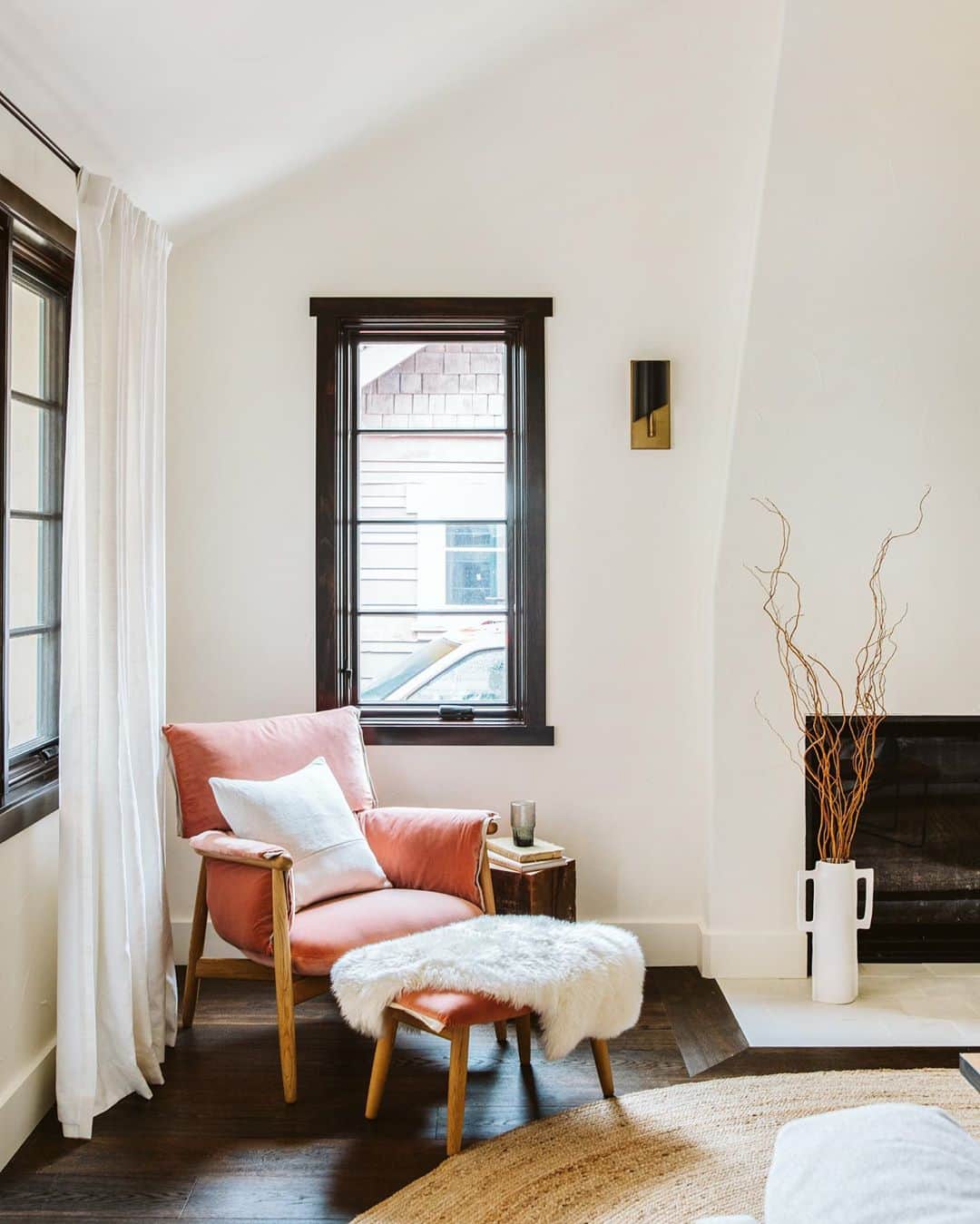 corner of living room with black casement window and red upholstered chair
