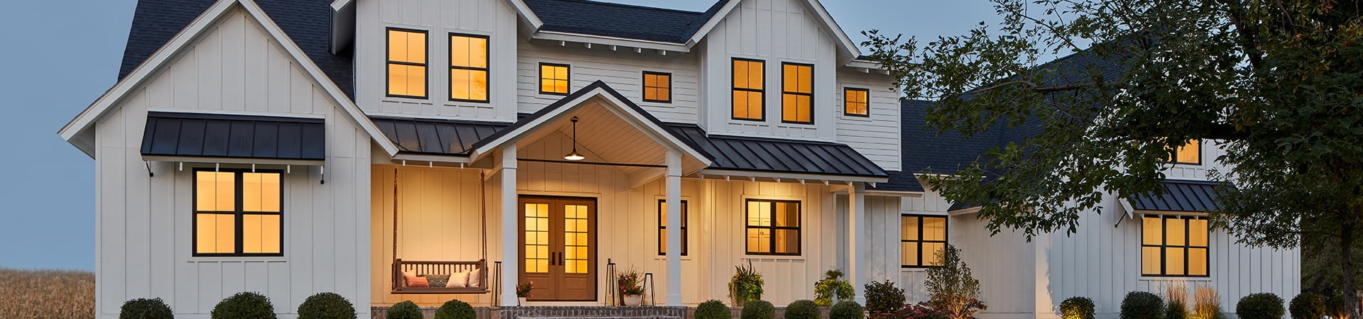 a home exterior at dusk with impervia double-hung windows