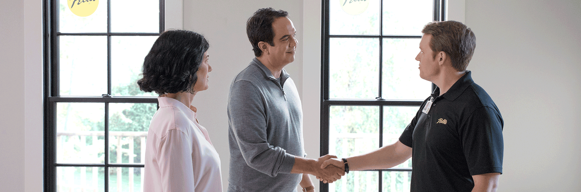 couple shaking a pella sales representative's hand